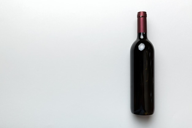 Une bouteille de vin rouge sur une table colorée Vue de dessus à plat avec espace de copie