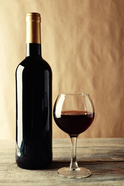 Une bouteille de vin rouge et un verre sur une table en bois