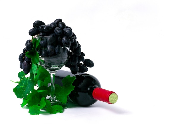 Bouteille de vin rouge, verre de vin avec raisins