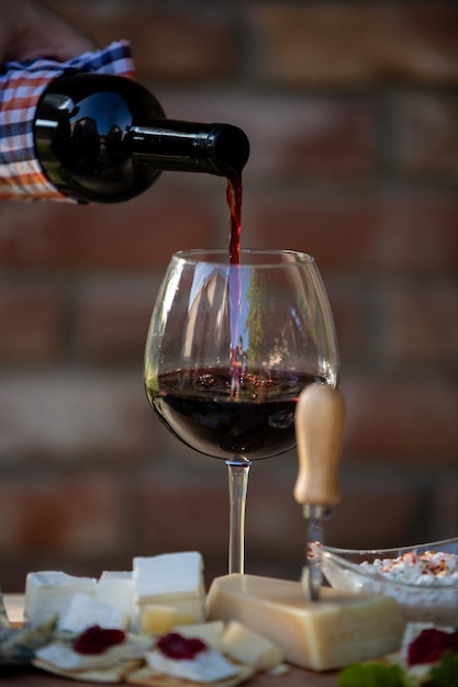 Bouteille de vin rouge versé dans le verre à vin sur la table à manger