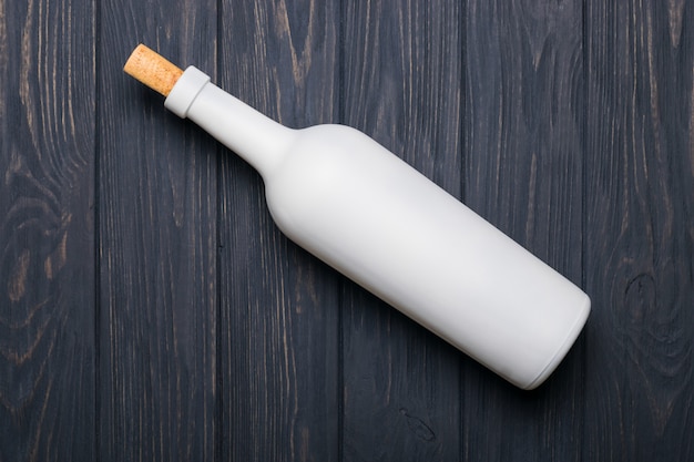 Bouteille de vin sur une table en bois sombre.