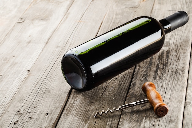 Bouteille de vin et tire-bouchon sur table en bois