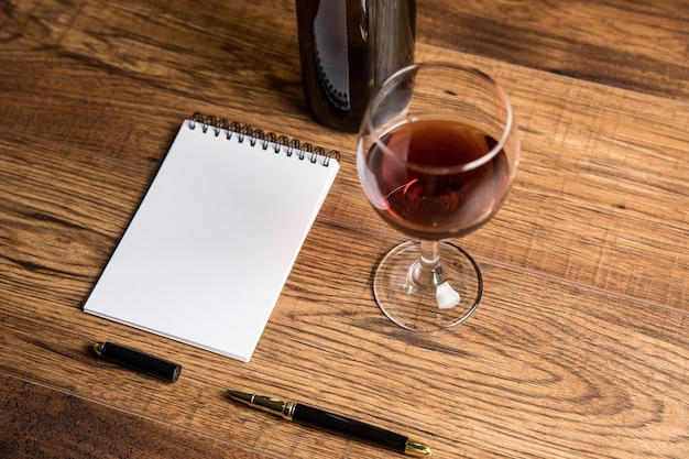 Bouteille de vin avec un verre et un bloc-notes