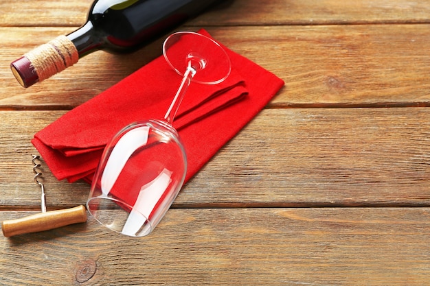 Bouteille de vin avec verre et tire-bouchon sur fond de bois