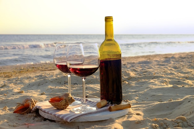 Bouteille de vin et verres au bord de la mer