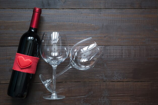 Bouteille de vin et verres sur planche de bois. Vue de dessus avec espace.