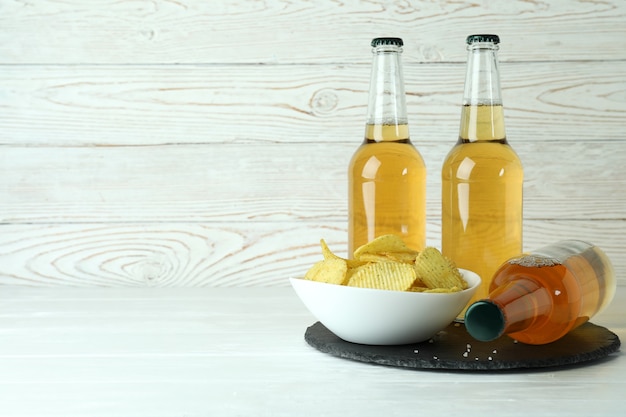 Bouteilles de bière et chips sur bois blanc