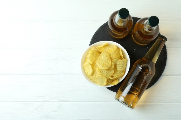 Bouteilles de bière et chips sur bois blanc