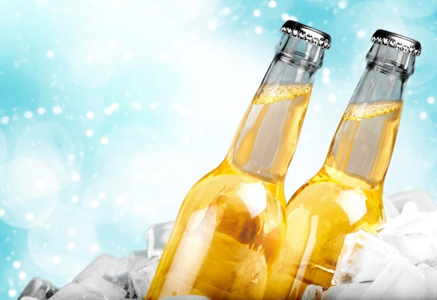 Bouteilles de bière dans la glace sur fond clair