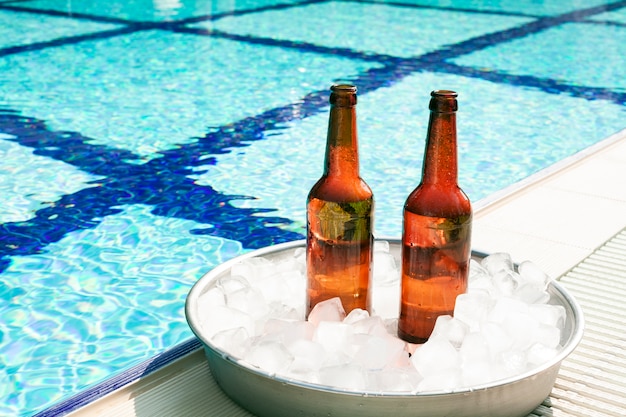 Photo bouteilles de bière dans un plateau avec de la glace