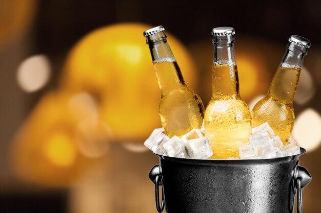 Photo bouteilles de bière dans le seau avec des glaçons isolés sur blanc