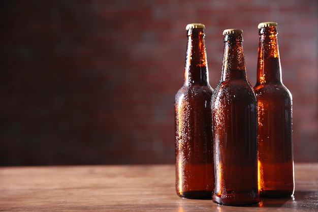 Bouteilles de bière en verre brun sur fond de mur de briques