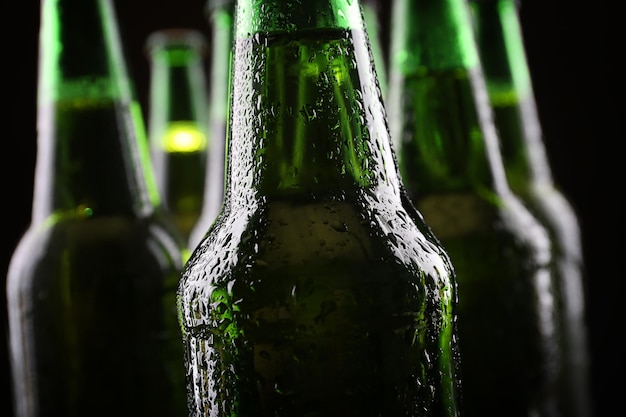 Bouteilles de bière en verre vert sur fond sombre se bouchent