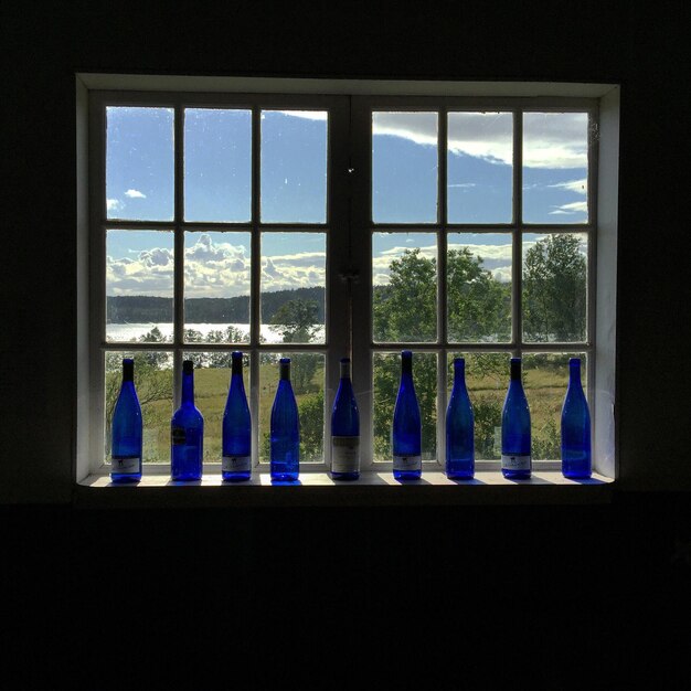 Des bouteilles bleues disposées sur la fenêtre de la maison