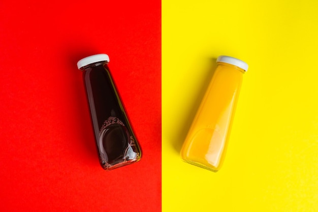 Bouteilles avec boisson halthy liquide jaune et rouge sur fond jaune et rouge Jus de cerise orange