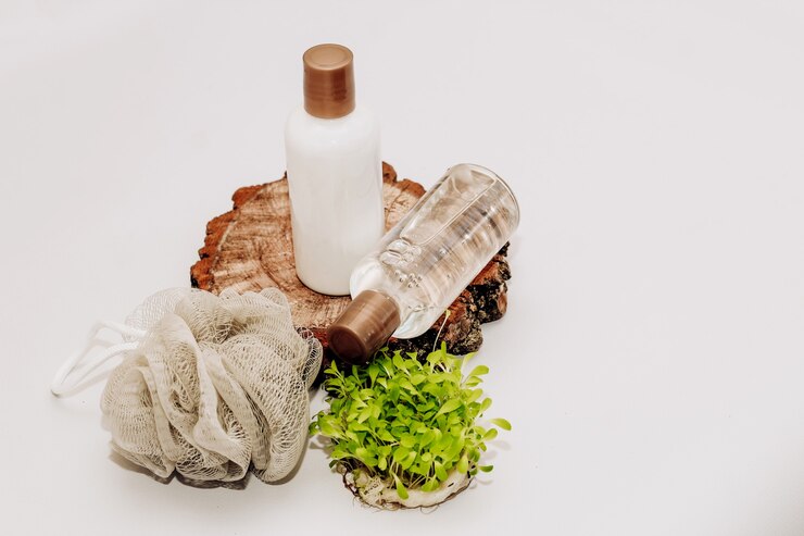 Photo bouteilles cosmétiques aux herbes de bain et gant de toilette sur fond en bois.