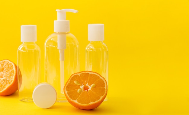 Bouteilles cosmétiques transparentes en plastique avec bouchon blanc et citrons sur jaune