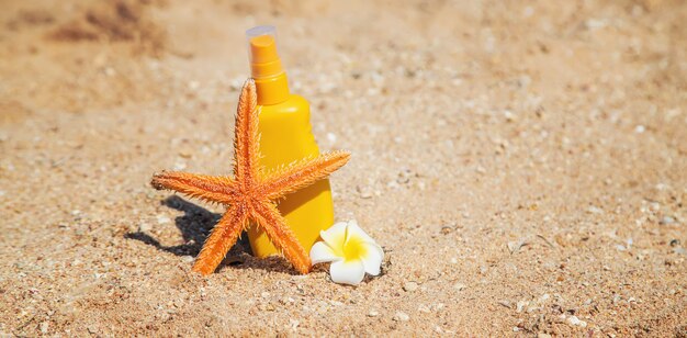 Bouteilles de crème solaire et une étoile de mer sur la plage