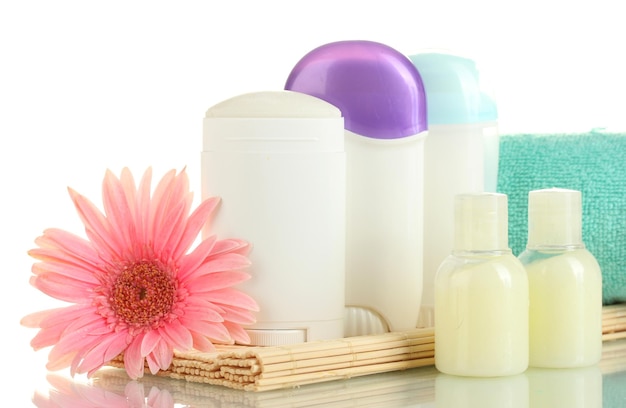 Photo bouteilles de déodorant et cosmétiques avec serviette isolé sur blanc