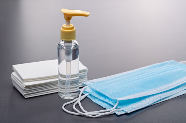 Bouteilles de désinfectant pour les mains, lingettes antibactériennes et masques faciaux. Prise de vue en studio.