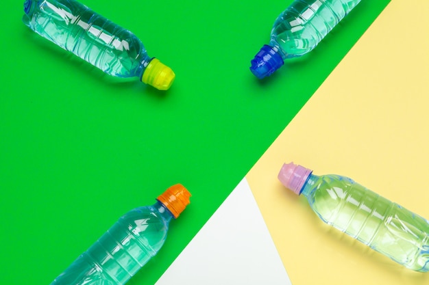 Bouteilles d'eau en plastique avec des bouchons de couleurs différentes sur la table