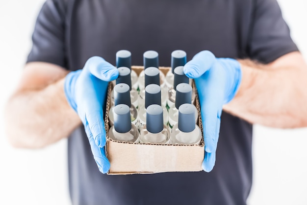 Bouteilles De Gel D'alcool D'hygiène Désinfectant Pour Les Mains Dans Les Mains D'un Homme Portant Des Gants Médicaux En Latex Et Un Masque De Protection Pendant Les Pandémies De Coronavirus Covid-19. Mesures D'hygiène Et De Sécurité Des Soins De Santé