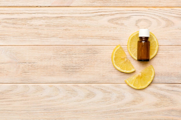 Bouteilles d'huile essentielle de citron sur fond de bois vue de dessus de médecine alternative avec espace de copie
