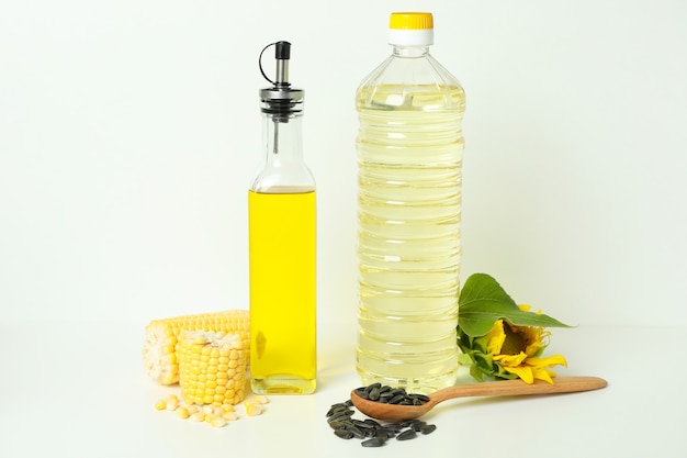 Bouteilles d'huile de tournesol et de maïs sur fond blanc