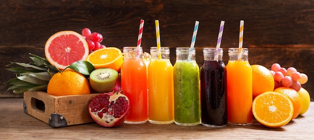 Photo bouteilles de jus de fruits avec des fruits frais