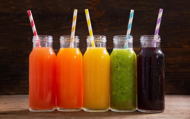 Bouteilles de jus de fruits sur une table en bois