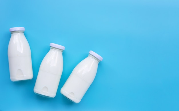 Bouteilles de lait sur fond bleu.