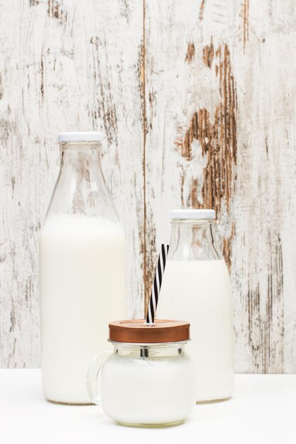 Photo bouteilles de lait sur un fond en bois