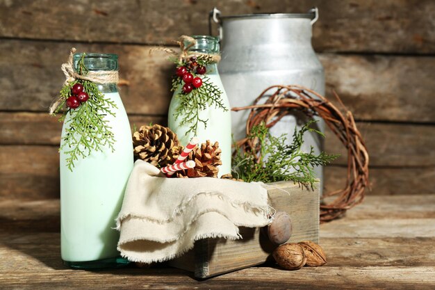 Photo bouteilles de lait frais avec décor naturel sur fond de bois
