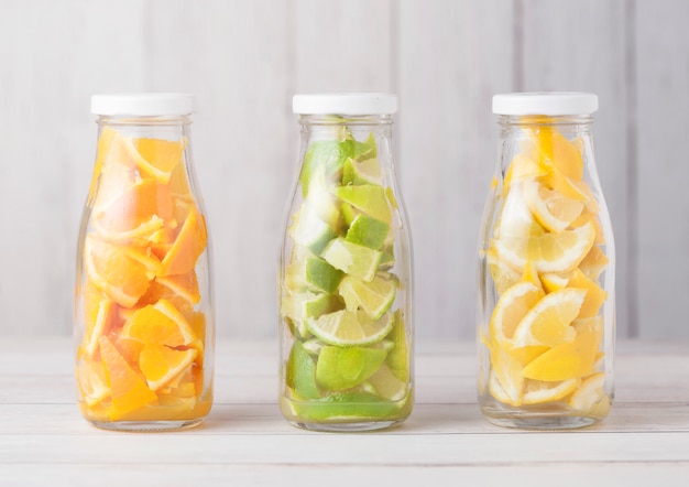 Bouteilles d'oranges avec des tranches de limes et de citrons