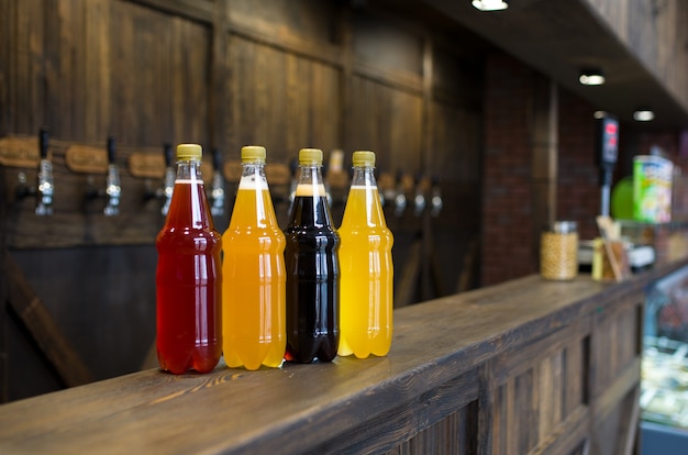 Bouteilles en plastique de bière légère et foncée sur un comptoir de pub.