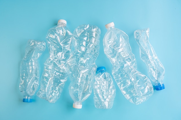 Bouteilles en plastique écrasées sur fond bleu. Concept d'utilisation du plastique de recyclage