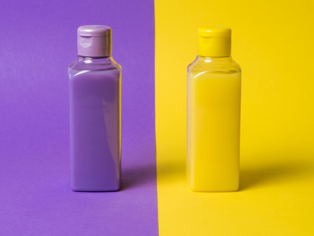 Bouteilles en plastique jaune et violet sur fond jaune et violet