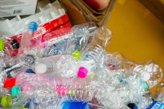 Bouteilles en plastique et papier carton dans la station de recyclage des ordures close up