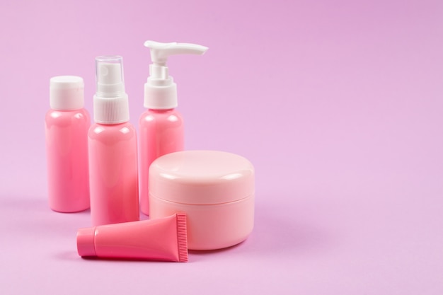 Bouteilles en plastique rose pour produits d'hygiène, cosmétiques, produits d'hygiène sur fond rose.