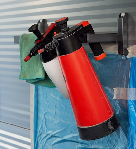 Photo bouteilles en plastique avec spray pour voiture accroché au mur en atelier de réparation automobile