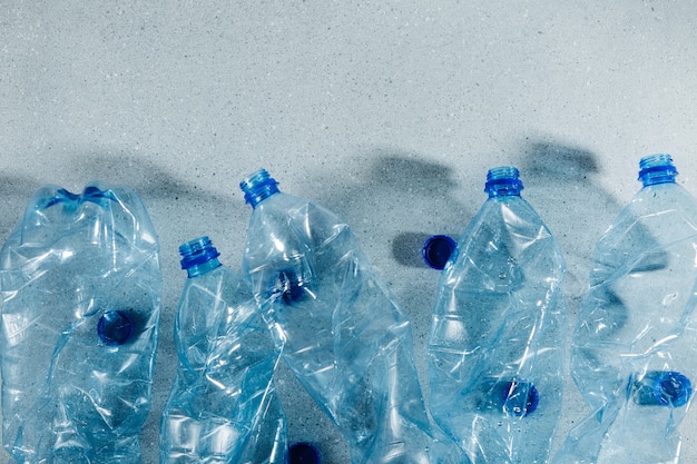 Bouteilles en plastique à usage unique bleues. Concept de recyclage du plastique et de l'écologie. Mise à plat, vue de dessus