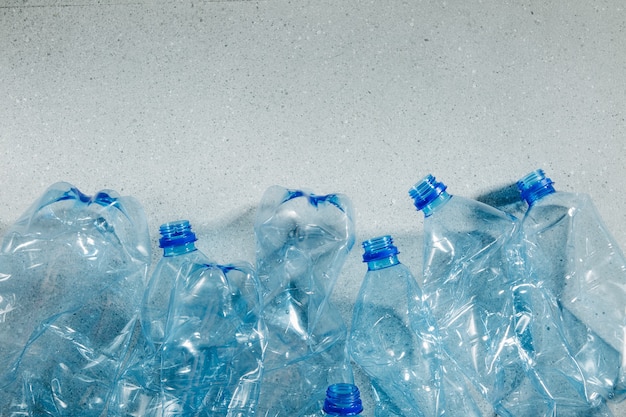 Bouteilles en plastique à usage unique bleues. Concept de recyclage du plastique et de l'écologie. Mise à plat, vue de dessus
