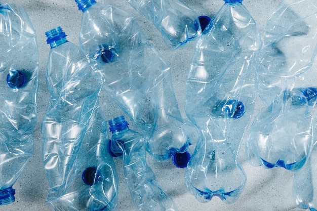 Bouteilles en plastique à usage unique bleues. Concept de recyclage du plastique et de l'écologie. Mise à plat, vue de dessus