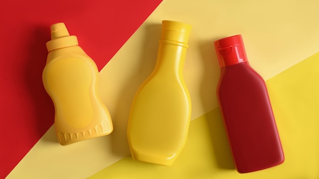 Bouteilles de sauce en plastique sur fond jaune et lu.