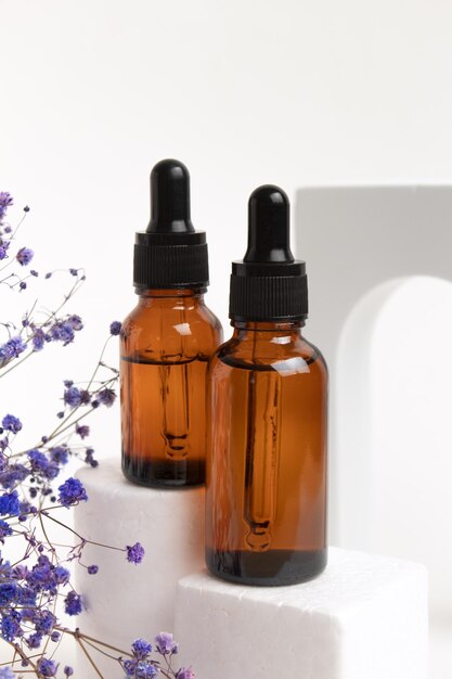 Bouteilles de sérum sans marque sur le podium Sérum d'huile d'acide hyaluronique avec collagène et peptides produit de soin de la peau Maquette d'emballage cosmétique marque de conception