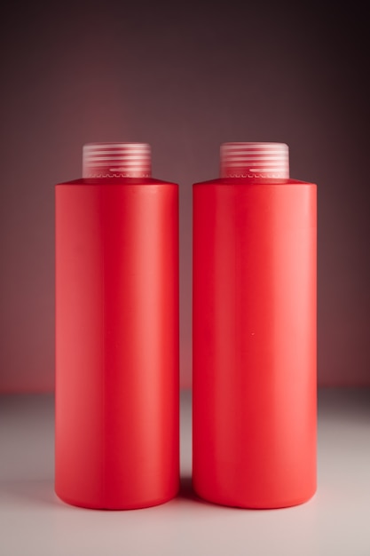 Bouteilles de shampoing sur fond rouge