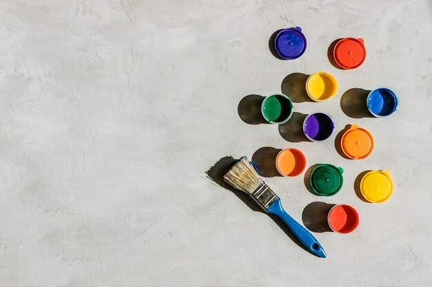 Bouteilles tempera multicolores et pinceau sur béton