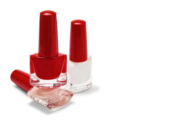 Bouteilles de vernis à ongles beiges et blancs rouges isolés sur fond blanc avec espace de copie mise au point sélective Concept de cosmétiques