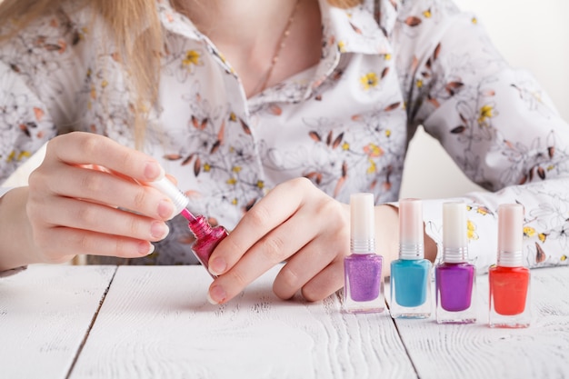 Bouteilles de vernis à ongles dans des mains féminines