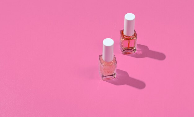 Bouteilles de vernis à ongles sur fond rose. Concept de beauté et de mode